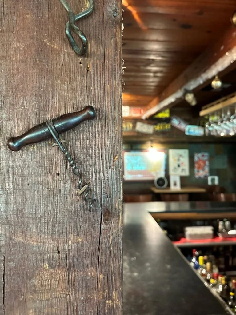 old corkscrew on bar post with partial bar view